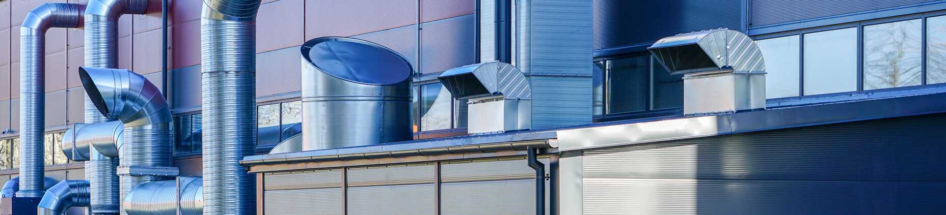 New modern factory heating and ventilation system with stainless steel pipes and chimneys