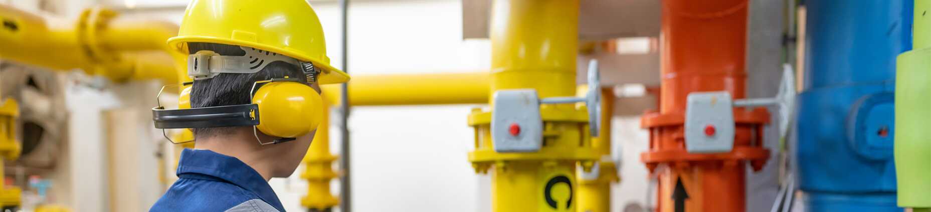 This image shows a person wearing a yellow hard hat and blue workwear.